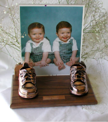 Bronzed shoes on walnut base with clear frame