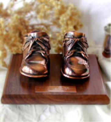 Bronzed shoes on walnut base