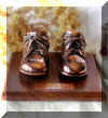 Bronzed shoes on walnut base