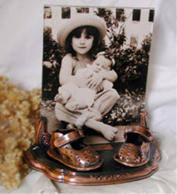 Bronzed shoes on bronze base with clear frame