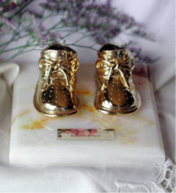 Gold finished shoes on white onyx base